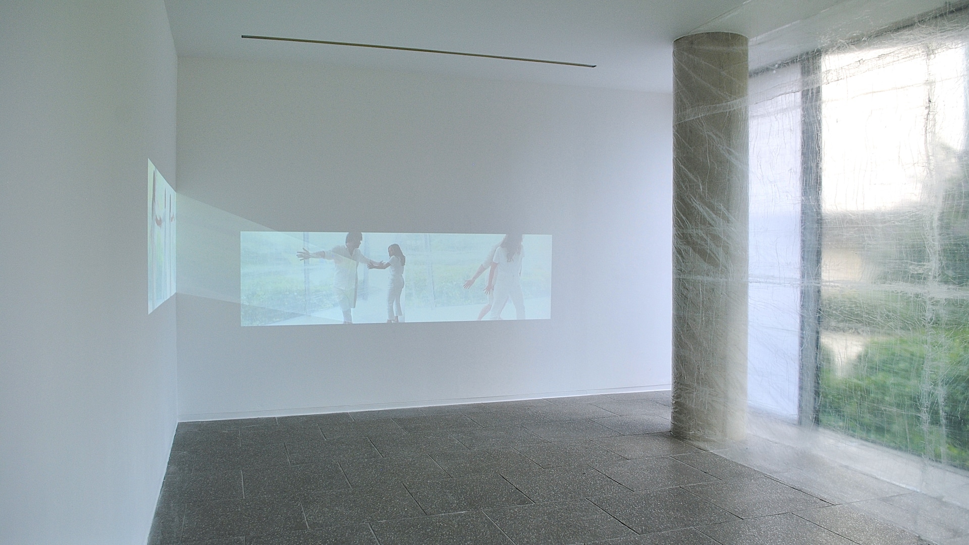 Cos Ahmet, A Meniscus Between, 2021 - Installation view. Two channel digital video projection, 5 mins 2 secs, audio, choreographic object, clear tape. Dimensions variable.